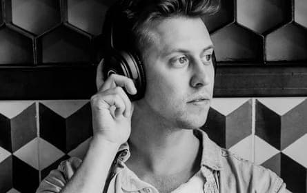 Person wearing headphones against geometric pattern